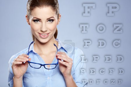 woman with trendy glasses on the background of eye test chart