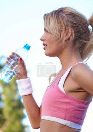 Woman drinking water after doing sports