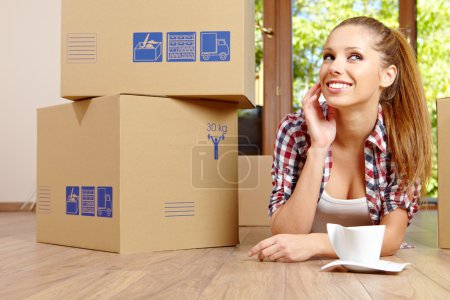 A beautiful single young woman unpacking boxes and moving into a