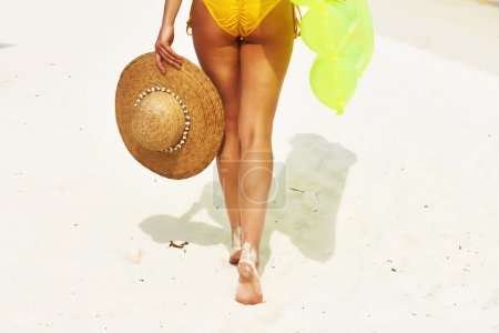 Woman with yellow inflatable raft at the beach