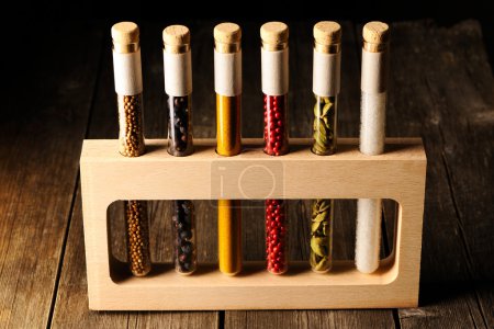 Spices in beakers on wooden table