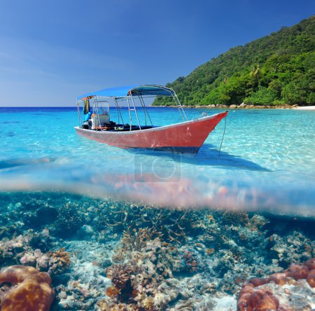 Beach and motor boat with coral reef underwater view
