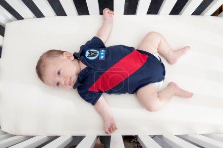Baby boy lying in a crib