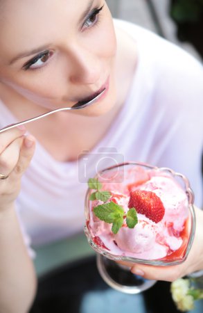 Cute lady eating a fruit ice-cream
