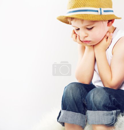 Sad boy with his straw hat