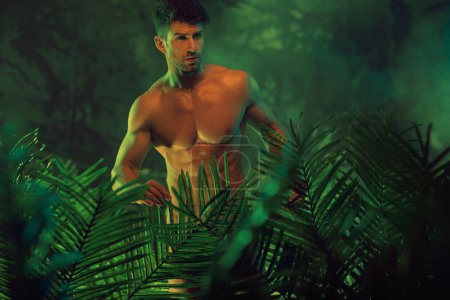 Handsome nude man in the hot jungle
