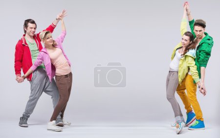 Two hip-hop couples dance and smile