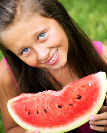 Cute girl eating juicy watermelon