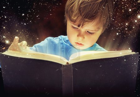 Amazed young boy with magic book