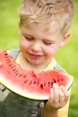 Portrait of a kid eating a slice of watermelon