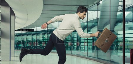 Running businessman with brown suitcase