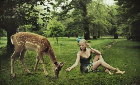 Adorable young lady playing with deer