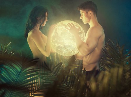 Nude couple holding the shiny Earth