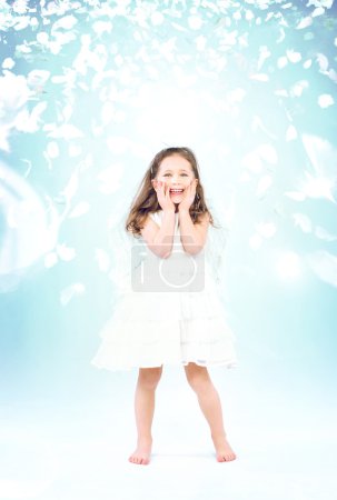 Little girl among flying rose petals