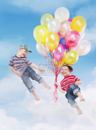 Smiling boys flying with balloons