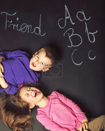Cute kids playing on the black board