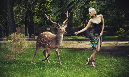 Young blonde lady running with deer