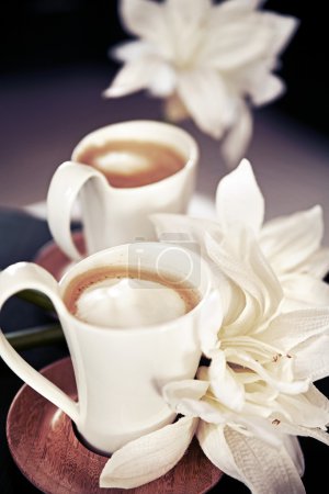 Cups of milk coffee with flowers