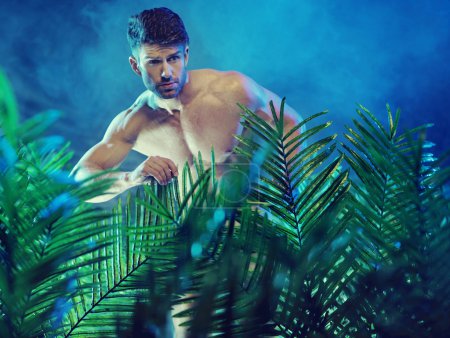 Attractive muscular man in the jungle