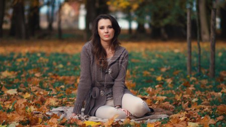 Beautiful woman relaxing in autumn park