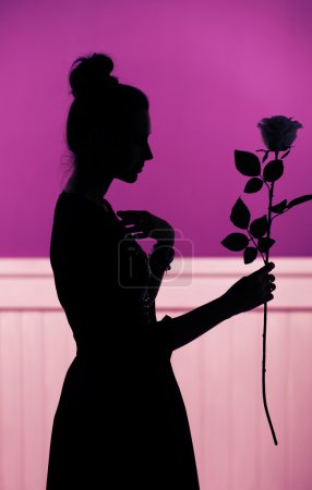 Female silhouette holding the rose