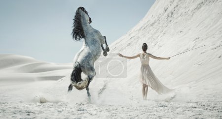 Pretty lady with huge horse on the desert