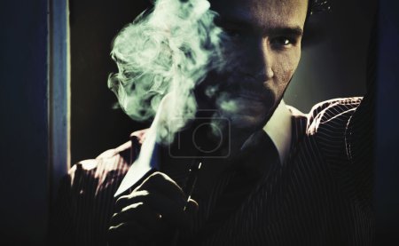 Smoking handsome man with serious look