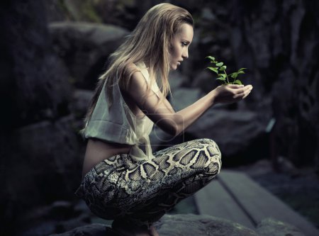 Beautiful young woman holding a plant