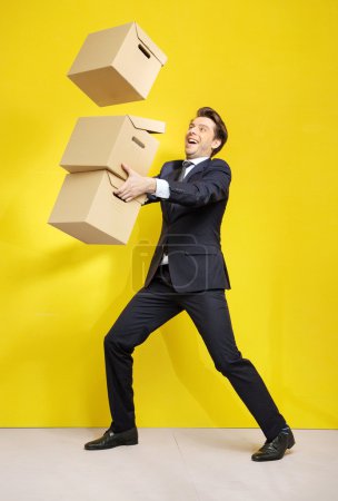 Cheerful businessman with paper boxes