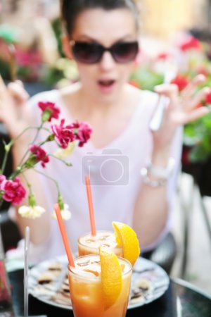 Surprised brunette lady staring at glasses of juice