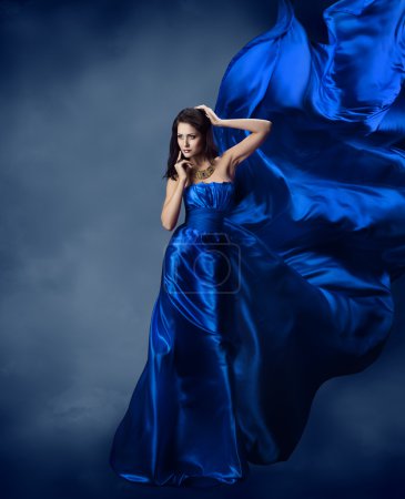 Woman in blue dress with flying blue silk fabric