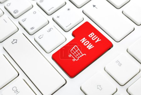 Shop buy now business concept. Red shopping cart button or key on white keyboard