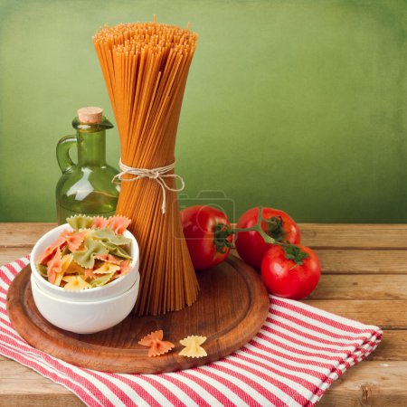 Italian pasta with tomatoes on striped tablecloth