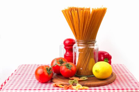 Spaghetti and vegetables on red tablecloth