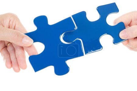 People putting two pieces of jigsaw together