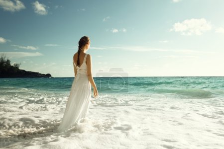 young woman standing in sea waves