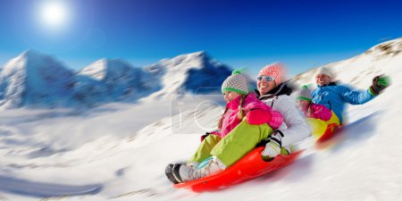 Winter fun, snow, family sledding at winter time