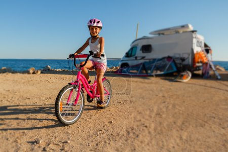Summer sport, summer vacation - lovely girl riding a bike sea coast