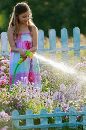 Watering, flower garden - beautiful girl watering roses