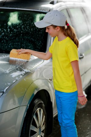 Car wash - a teenage girl washes the car