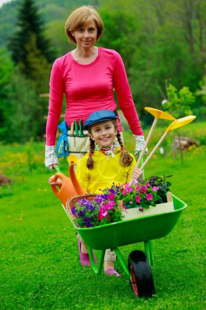 Gardening, planting - girl helping mother in the garden