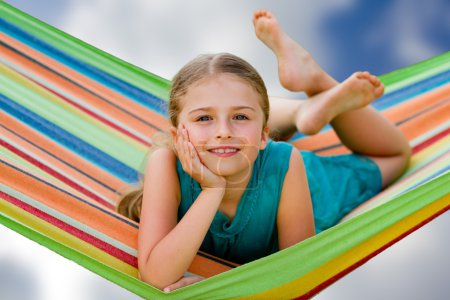 Summer vacations - lovely girl in colorful hammock