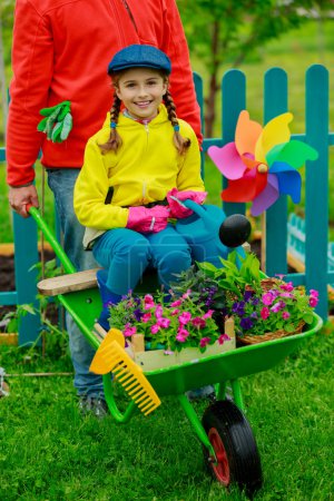 Gardening, planting - girl in barrow helping father