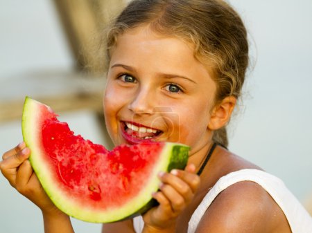 Summer joy, lovely girl eating fresh watermelon on the beach