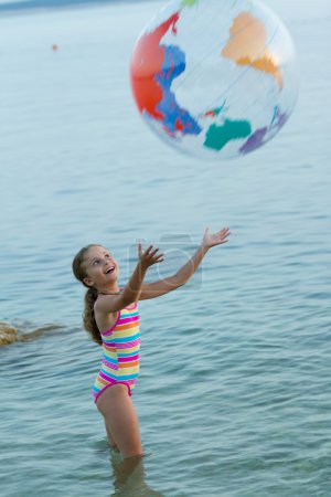 Summer game, young girl playing in the sea