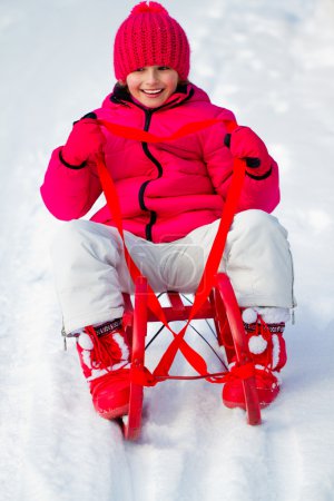 Winter, snow, sledding - girl has a fun on snow