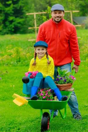 Gardening, planting - girl in barrow helping father
