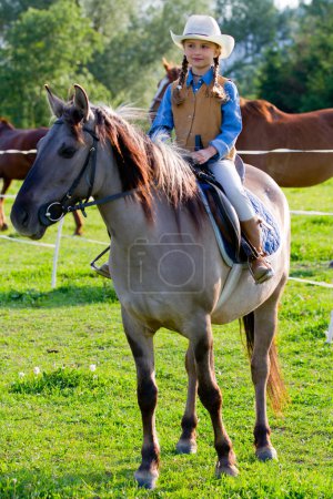 Horseback riding - lovely cowgirl is riding a horse