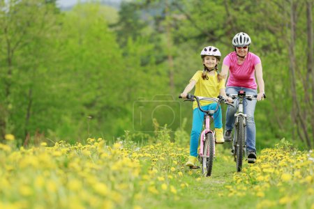 Bike riding - young girl with mother on bike