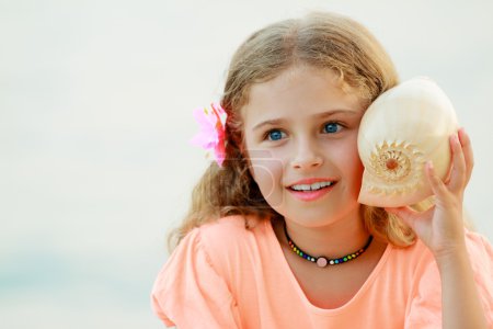 Summer beach, summer joy - lovely girl with shell at the beach